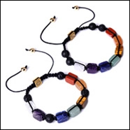 Macro shot of colorful natural stone beads with black braided rope and gold charms