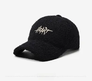 Detailed side view of black fleece baseball cap with white cursive heart embroidery
