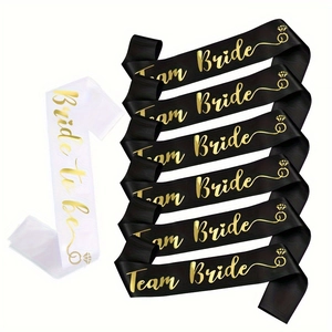 Detail of white Bride to be and black Team Bride sashes with gold lettering