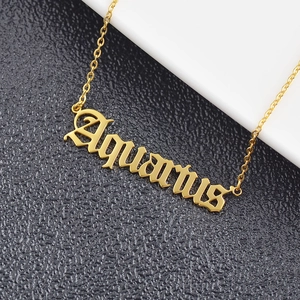 Close-up of golden stainless steel Aquarius zodiac pendant with gothic font and O-chain