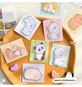 Detail of cute animal-shaped sticky notes in pastel colors on a round wooden tray