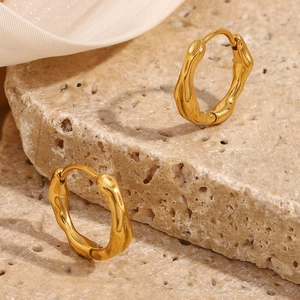 Macro shot of 18K gold plated stainless steel lava texture earrings on stone