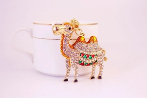 Detailed close-up of a golden desert camel keychain featuring vibrant sparkling rhinestones