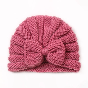 Detail view of pink baby knit turban hat featuring a large decorative bow on top