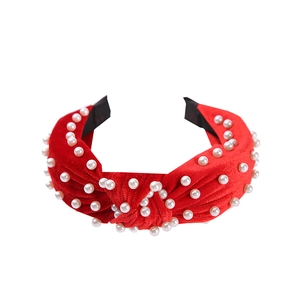 Close-up of red velvet knotted headband featuring detailed white faux pearl embellishments