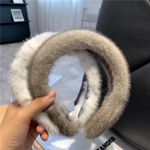 Detail showing the plush mink fur texture of the white and taupe headband accessory