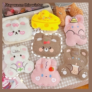 Detail of plush cartoon hot water bottle covers in bear, rabbit, and cheese shapes