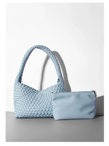 Dettaglio borsa tote in pelle PU azzurra intrecciata a mano con pochette coordinata
