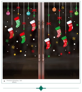 Calze di Natale appese e ornamenti colorati su una porta di vetro decorata