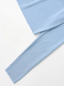 Dettaglio del tessuto a maglia azzurro con trama a costine e cuciture rifinite
