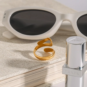 Minimalist golden wrap open ring with high-polished metal finish in a luxury lifestyle setting