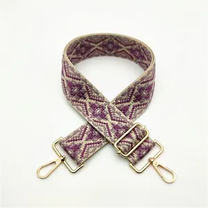 Close-up of ethnic woven strap with purple geometric pattern and gold metal hooks