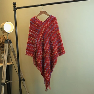 Vue détaillée d'un poncho en tricot rouge à col en V avec motifs ondulés colorés et franges
