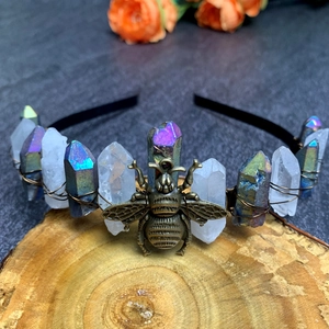 Detail of crystal crown showing antique bronze bee charm and purple stones on black headband