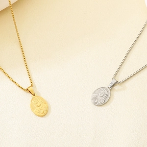 Detail of gold and silver Virgin Mary relief pendants on textured beige fabric