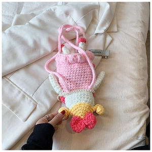 Detailed close-up of handmade crochet bag featuring pink yarn and a pearl chain strap