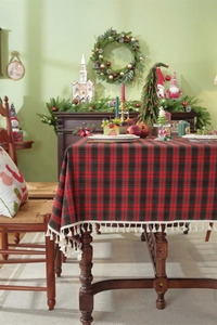 Close-up of festive red and green plaid tablecloth with decorative white fringe edges