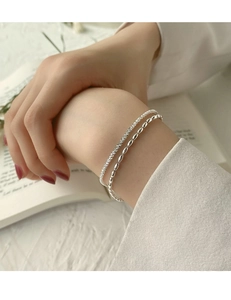 Makroaufnahme des eleganten doppelstöckigen S925 Silberarmbands mit Sternenperlen am Handgelenk