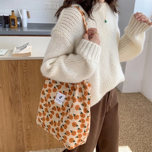 Close-up of orange floral pattern and corduroy texture on the large shoulder bag
