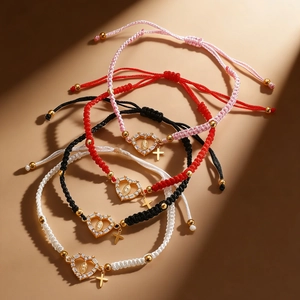 Detailed macro view of woven religious bracelets with gold-plated Mary and cross pendants