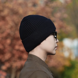 Classic black ribbed knit beanie for men, warm winter hat shown in outdoor setting