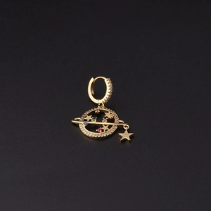 Macro shot of gold planet earring with colorful zircon stones and hanging star charm