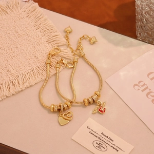 Set of two 18K gold-plated snake bone bracelets with heart and guitar charms