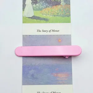Detailed view of a 6cm pink matte duckbill hair clip on a floral artistic card