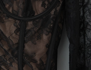 Détail du tissu en dentelle florale noire et structure en mesh du haut corset