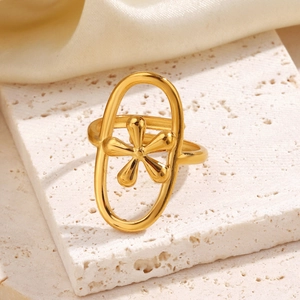Elegant gold oval geometric ring with floral design on cream stone background