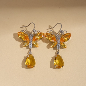 Detail of butterfly drop earrings with amber yellow crystals in silver-tone finish