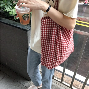 Detail of red and white checkered canvas tote bag with thick fabric and tie handles