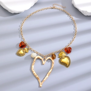 Vintage gold zinc alloy necklace with hollow heart and resin beads on gray surface