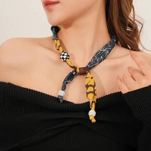 Close-up of retro fabric necklace with patterned wooden beads and a heart-shaped pendant