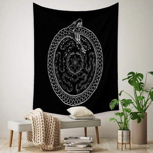 Detail of bohemian black wall tapestry featuring a white mystical ouroboros snake design