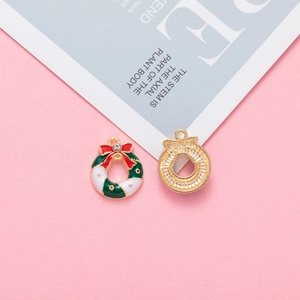 Detail of Christmas wreath pendant with red bow and enamel finish on pink background