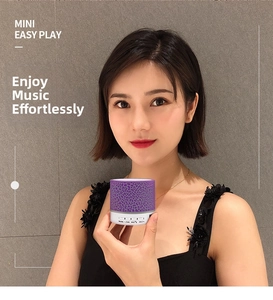 Mini portable crackled purple Bluetooth speaker held by a hand showing compact size