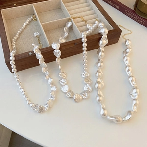 Close-up of irregular pearl necklaces and heart pendant in a wooden jewelry box