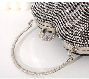 Macro detail of silver rhinestone evening bag with luxury ring clasp and snake chain