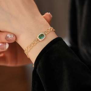 Detail of vintage gold bracelet with emerald green zircon and pavé crystals on wrist