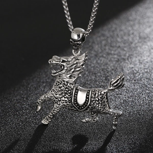 Detailed close-up of a silver mythological creature pendant with intricate scale textures