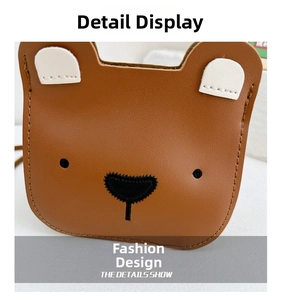 Close-up of cute brown leather bear bag with embroidery and white ears details