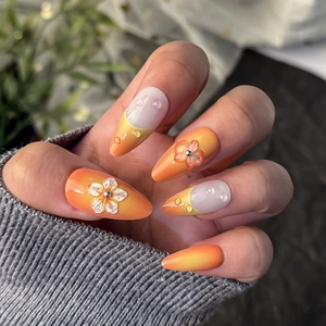 Faux ongles amande french avec dégradé orange, fleurs 3D et effet gouttes d'eau