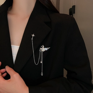 Vintage silver swan brooch with rhinestone tassels and star pin on a black suit jacket