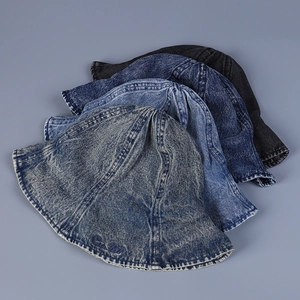 Détail de quatre bobs en denim délavé en divers tons de bleu et gris avec broderie fine