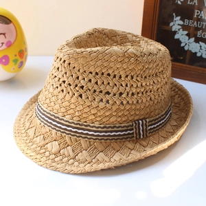 Detail of classic straw fedora hat featuring a stylish brown striped decorative band