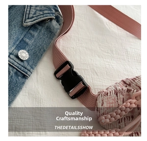Macro detail of pink tweed fabric and black plastic buckle on the causal chest bag