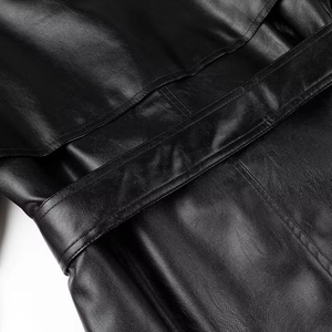 Close-up of premium black leather texture with detailed stitching and waist belt detail