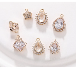 Vue macro de pendentifs DIY dorés ornés de zircons cubiques blancs étincelants