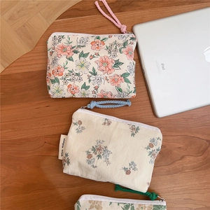 Detailed view of floral cotton coin purses with zippers and braided wrist straps